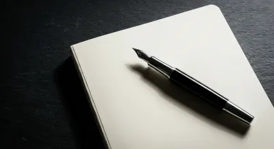 Stylo plume élégant sur un carnet, icône de la création d'entreprise.